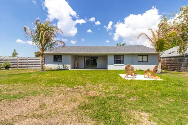 a view of a house with pool and chairs