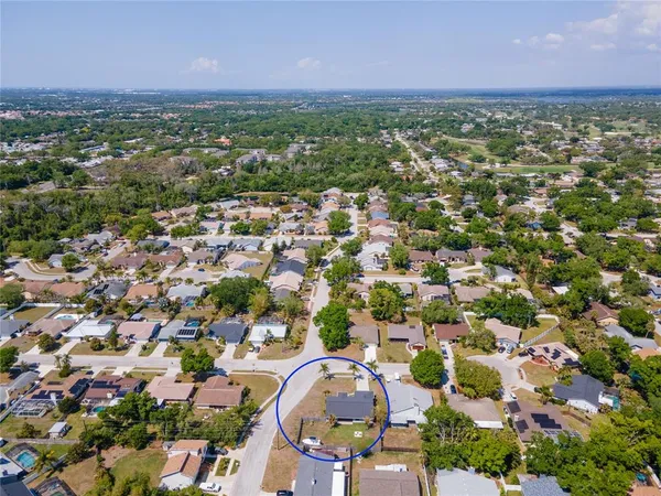 an aerial view of residential houses with outdoor space and trees