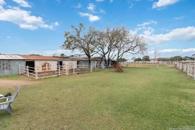 a view of a swimming pool with lawn chairs and plants