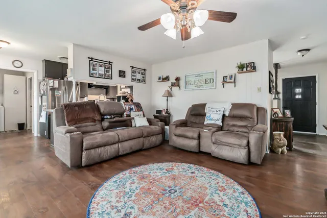 a living room with furniture and a open to kitchen view