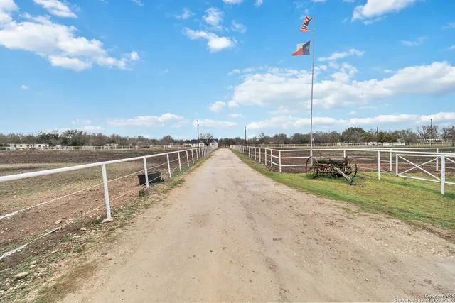 a view of a yard with wooden fence