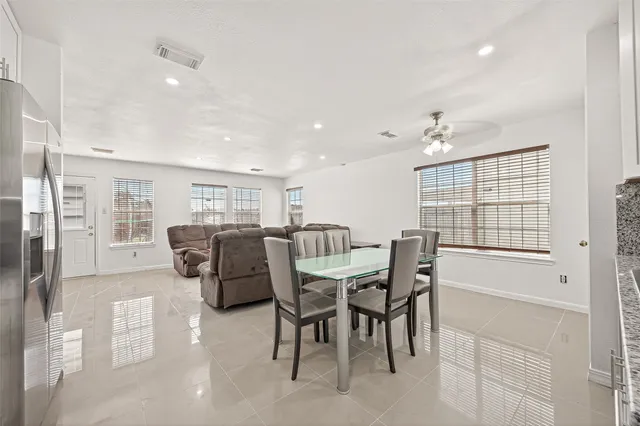 a kitchen with a refrigerator and white cabinets
