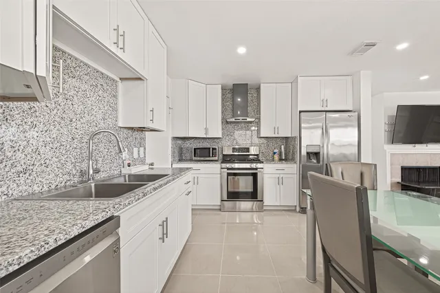a kitchen with stainless steel appliances granite countertop a sink stove and cabinets