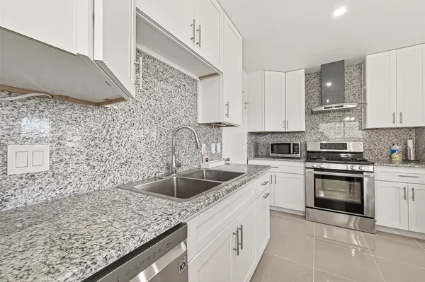 a spacious bedroom with a large bed and a chandelier