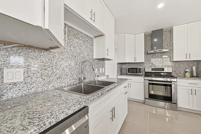 a kitchen with stainless steel appliances granite countertop a stove and a microwave