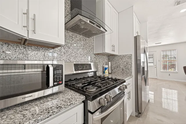 a stove top oven sitting inside of a kitchen