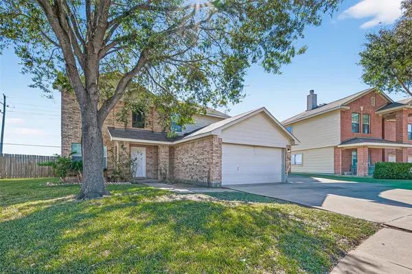 a view of a house with a small yard and a large tree