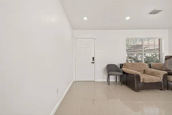 a bedroom with a large bed and chandelier fan