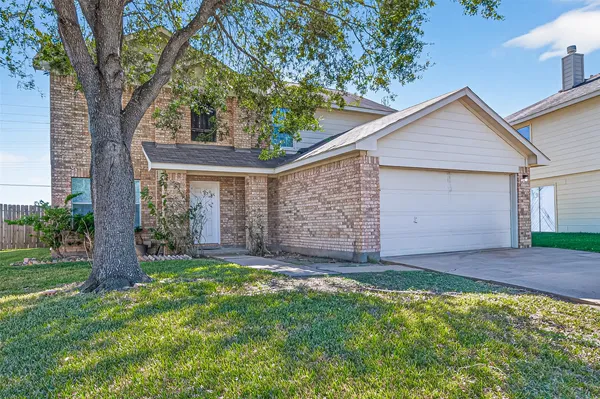 front view of a house with a yard and garage