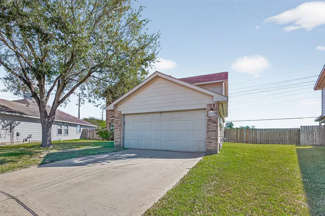 front view of a house with a yard and garage
