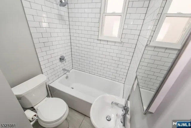 a white toilet sitting next to a bath tub and shower