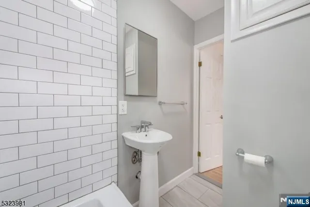 a bathroom with a sink a toilet and mirror