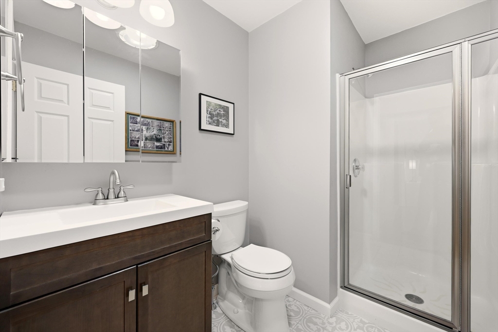 175 Leonard Street, Unit 2 Raynham, MA 02767 - Photo 13 of 27 a bathroom with a sink a toilet a mirror and shower