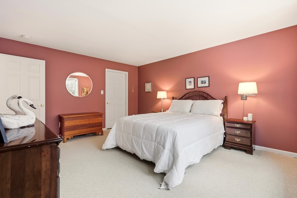175 Leonard Street, Unit 2 Raynham, MA 02767 - Photo 16 of 27 a bedroom with a bed and a lamp with the dresser