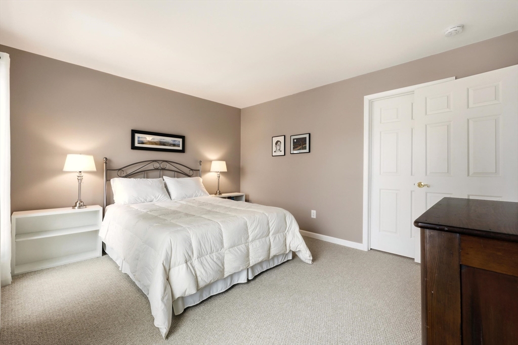 175 Leonard Street, Unit 2 Raynham, MA 02767 - Photo 19 of 27 a bedroom with a bed and a night stand