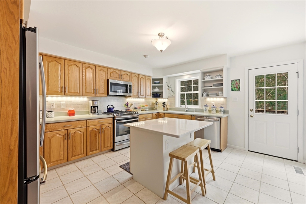 175 Leonard Street, Unit 2 Raynham, MA 02767 - Photo 5 of 27 a kitchen with a stove a sink and a refrigerator