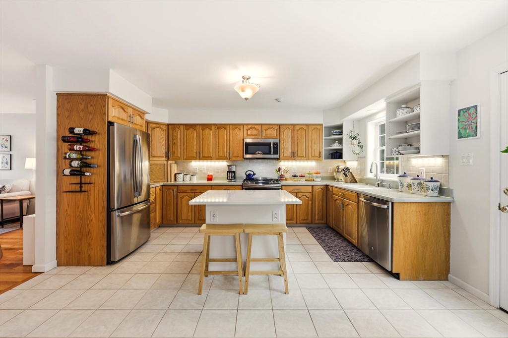 175 Leonard Street, Unit 2 Raynham, MA 02767 - Photo 7 of 27 a kitchen with stainless steel appliances a refrigerator sink and cabinets
