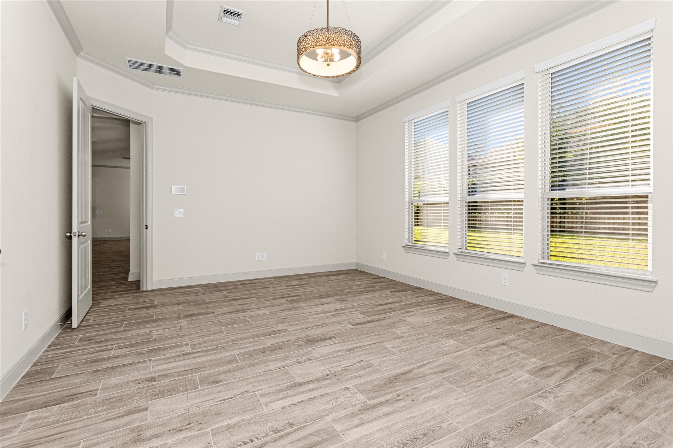 209 Fox Trotter Spring, TX 77382 - Photo 16 of 33 Spacious and bright owner's suite featuring elegant flooring, abundant natural light, and a stylish tray ceiling. Your perfect retreat awaits!
