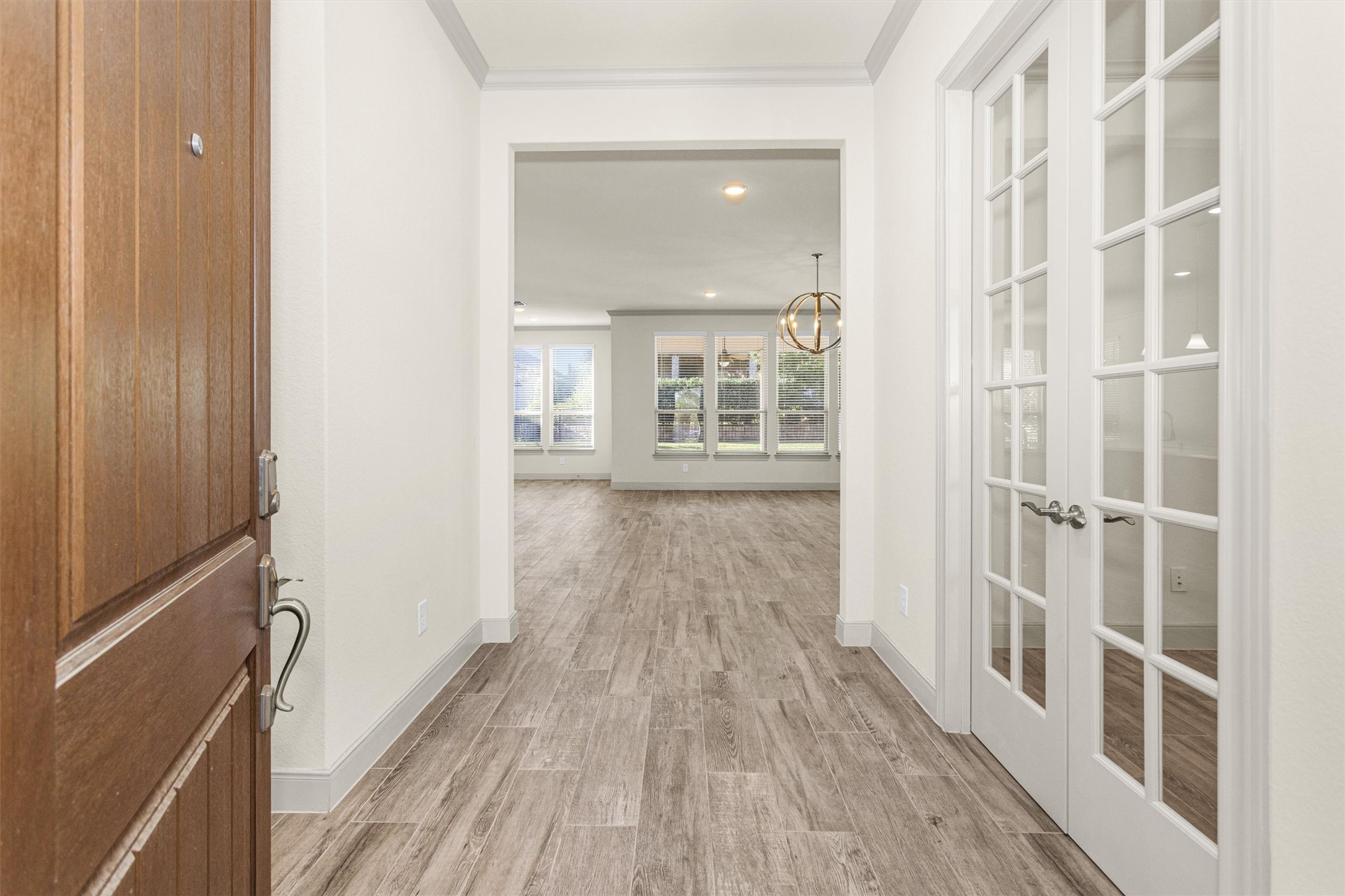 209 Fox Trotter Spring, TX 77382 - Photo 4 of 33 Step into a welcoming entryway featuring a study with elegant French doors and stylish wood-look tile flooring.