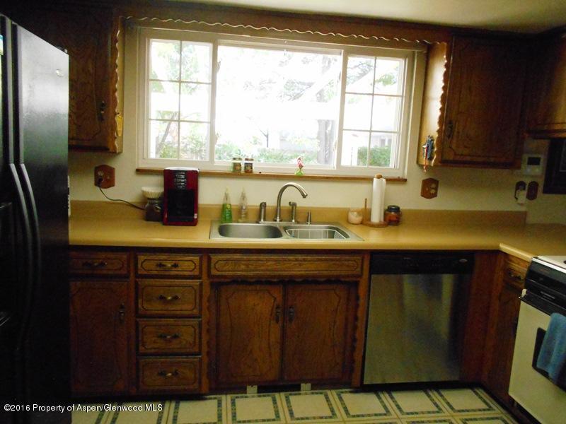 1321 East 8th Street Rifle, CO 81650 - Photo 5 of 15 a kitchen with a sink a window and cabinets