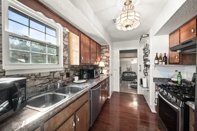 a kitchen with stainless steel appliances a stove sink and cabinets