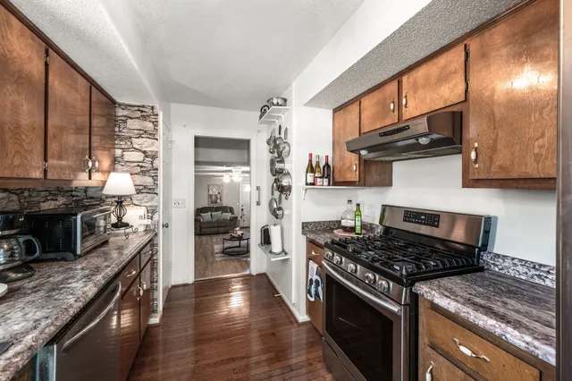 a kitchen with stainless steel appliances granite countertop a stove and a refrigerator