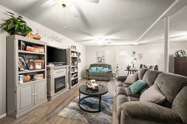 a living room with furniture a flat screen tv and a fireplace