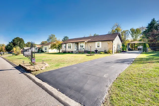 a view of a house with a yard and palm trees