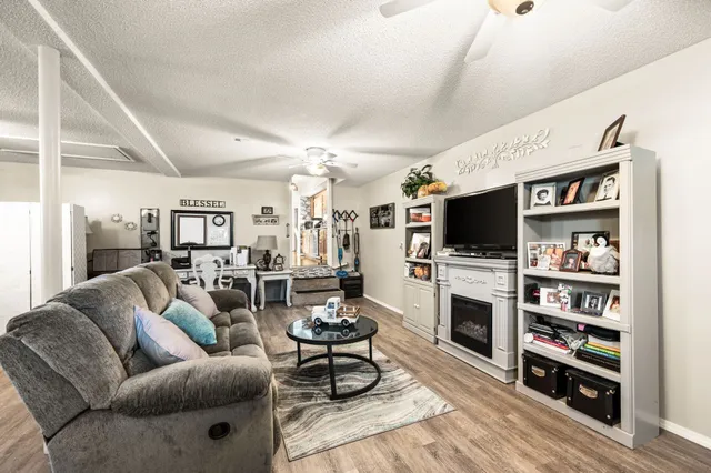 a living room with furniture a flat screen tv and a fireplace