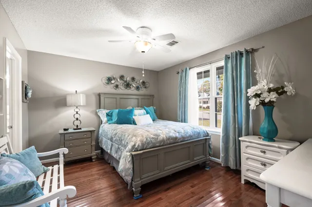 a bedroom with a bed wooden floor and window