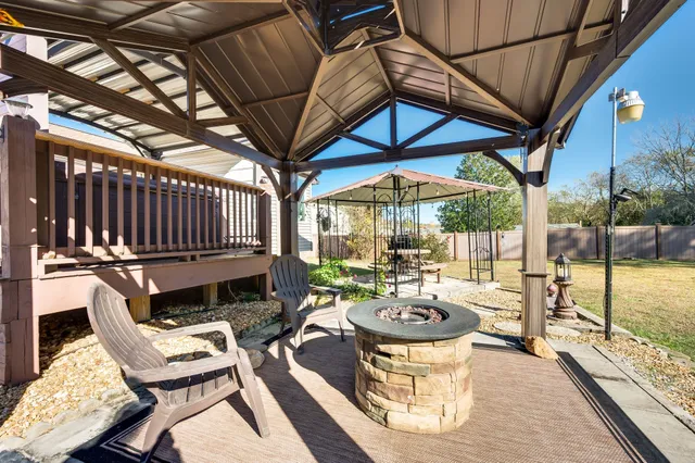 a view of a patio with table and chairs potted plants with wooden floor and fence