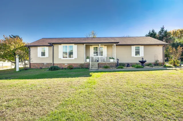 a front view of a house with yard and green space