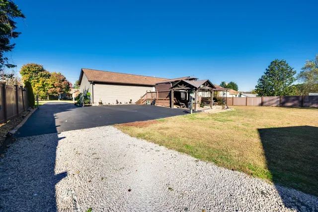 a view of a large house with a big yard and large tree