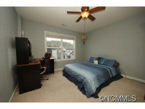 334 Wildbriar Road Fletcher, NC 28732 - Photo 15 of 20 a bedroom with a bed and a chandelier