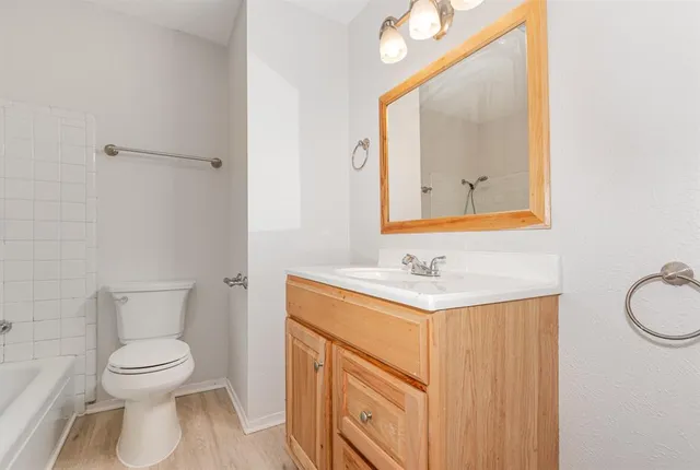a bathroom with a toilet sink vanity and mirror