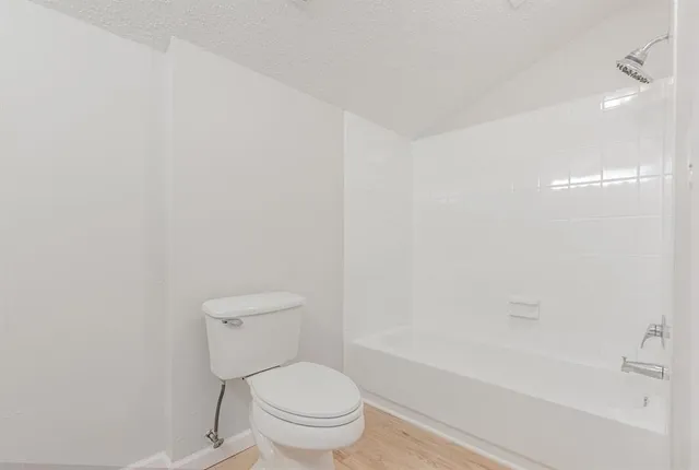 a white toilet sitting next to a bath tub