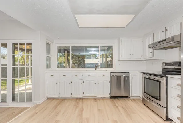 a kitchen with granite countertop white cabinets and white appliances