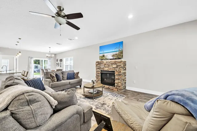a living room with furniture a fireplace and a ceiling fan
