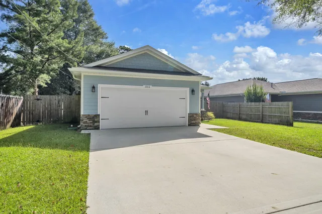 a front view of house with yard and car parked