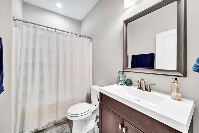 a bathroom with a toilet a sink and a mirror