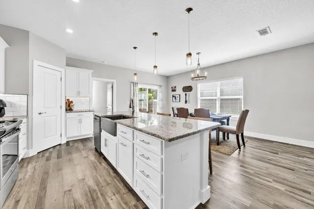 a kitchen with counter top space and wooden floor