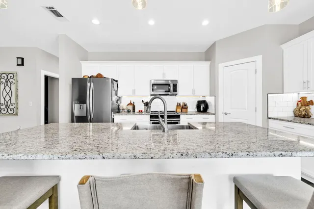 a kitchen with stainless steel appliances granite countertop a sink and refrigerator