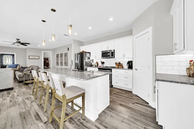 a kitchen with white cabinets and stainless steel appliances
