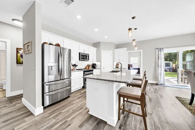 a kitchen with stainless steel appliances granite countertop a sink and refrigerator