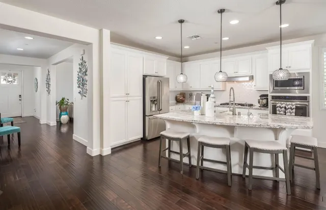 a kitchen with kitchen island granite countertop a sink a center island and cabinets