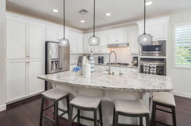 a kitchen with stainless steel appliances granite countertop a sink stove and refrigerator