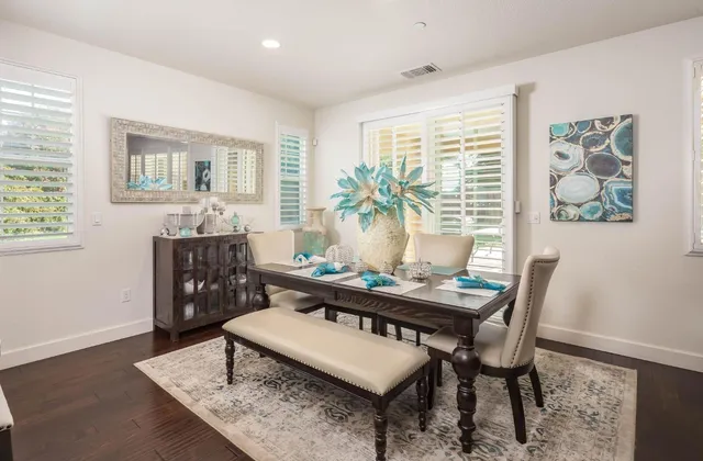 a view of a dining room with furniture a rug and wooden floor