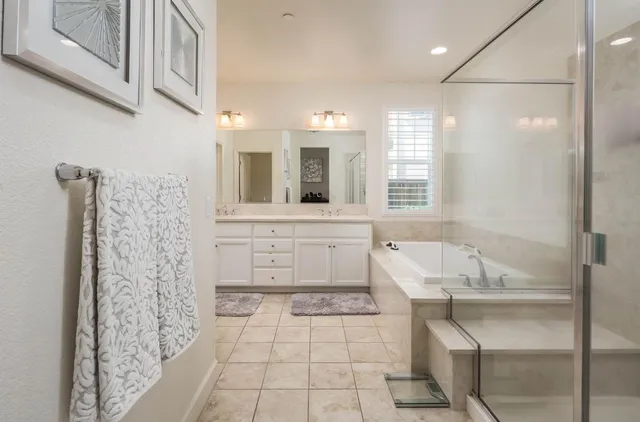 a spacious bathroom with a tub sink and mirror