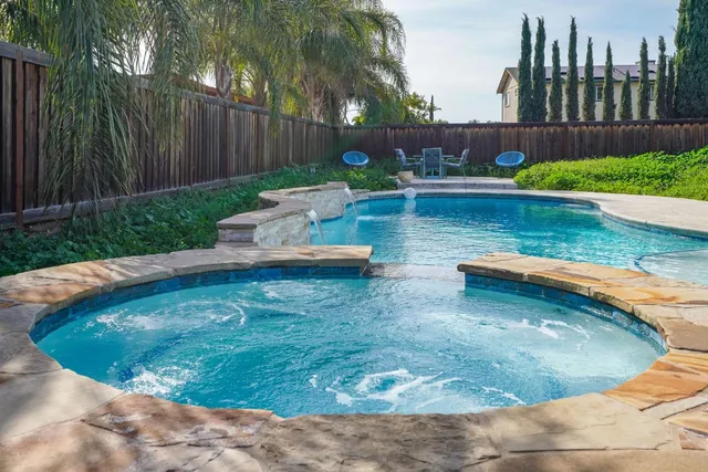 a view of a swimming pool with a yard and plants