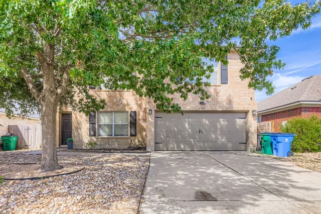 a front view of a house with a yard and a garage